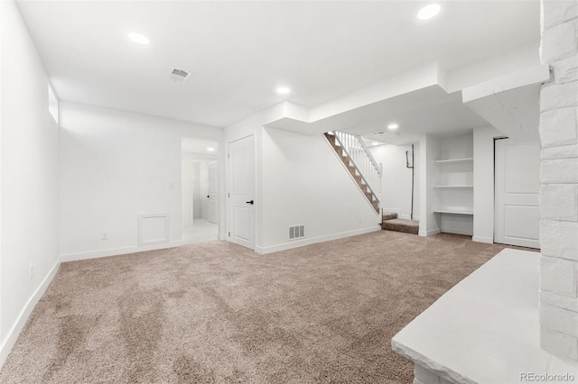 unfurnished living room featuring built in shelves and carpet floors