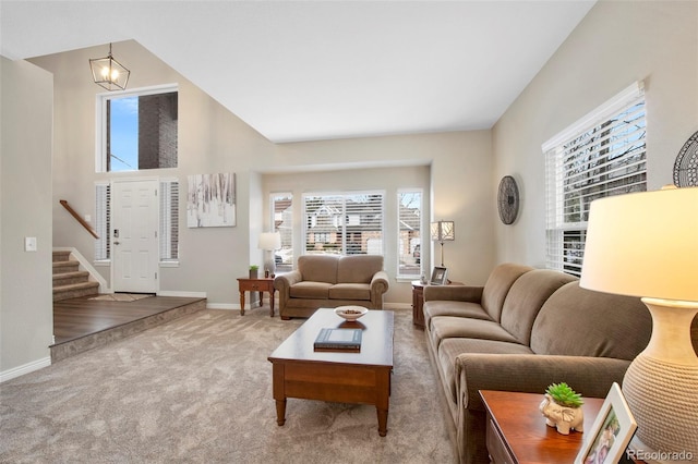 living room featuring a notable chandelier, a towering ceiling, and carpet floors