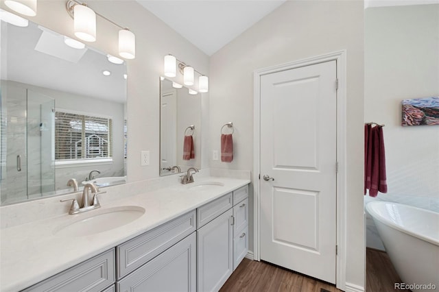 bathroom with hardwood / wood-style flooring, lofted ceiling, vanity, and independent shower and bath