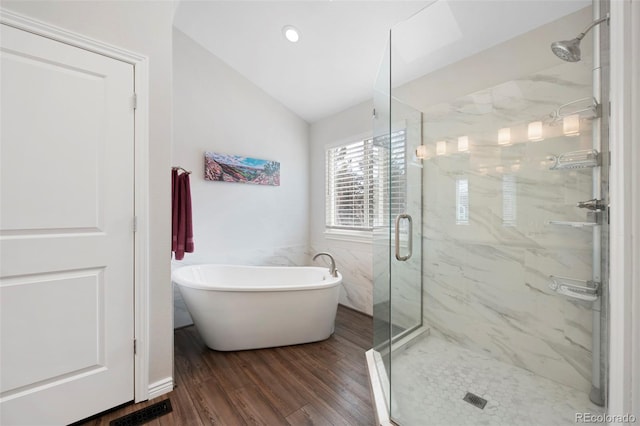 bathroom featuring hardwood / wood-style flooring, vaulted ceiling, and independent shower and bath