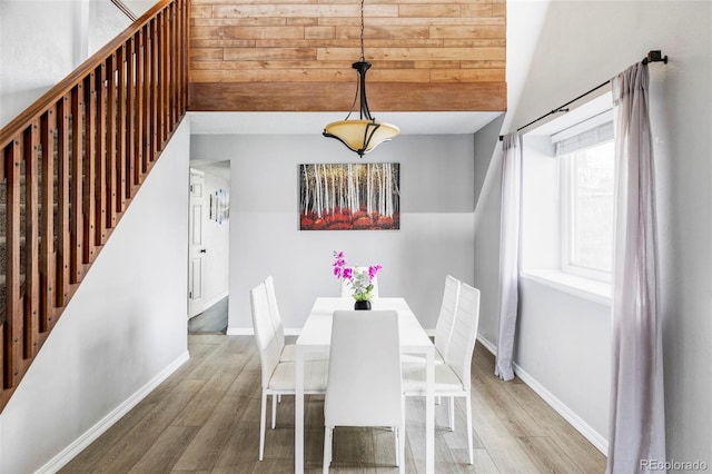 unfurnished dining area featuring stairs, baseboards, and wood finished floors