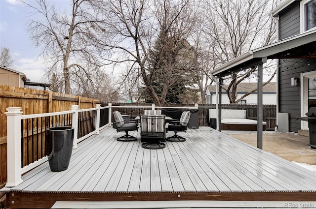 deck featuring outdoor dining space, a fenced backyard, and a hot tub