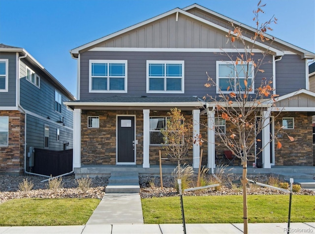 18726 E 99th Ave, Commerce City, CO 80022 - craftsman-style house featuring covered porch, a front lawn, stone siding, and board and batten siding