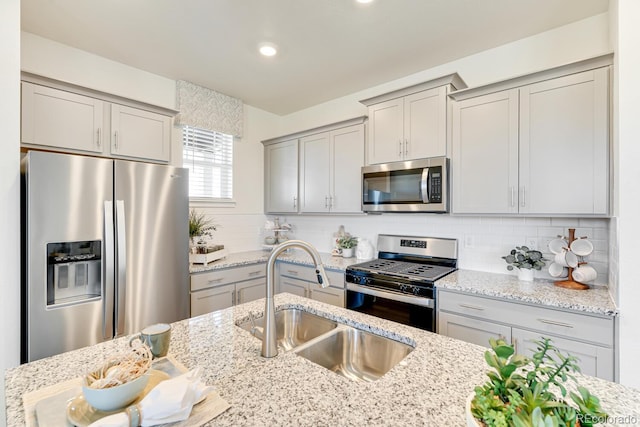 18726 E 99th Ave, Commerce City, CO 80022 - kitchen with appliances with stainless steel finishes, gray cabinets, light stone countertops, tasteful backsplash, and recessed lighting