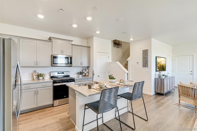 18726 E 99th Ave, Commerce City, CO 80022 - kitchen featuring stainless steel appliances, gray cabinetry, backsplash, light wood-style floors, and recessed lighting