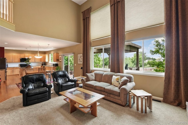 15962 W 70th Dr, Arvada, CO 80007 - living area featuring light colored carpet, a high ceiling, and recessed lighting
