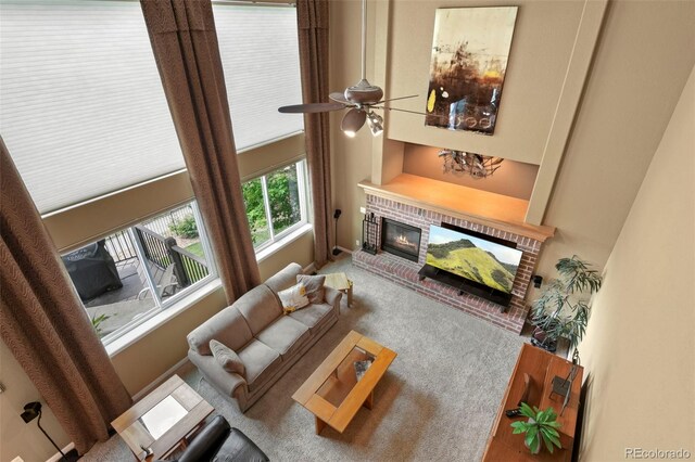 15962 W 70th Dr, Arvada, CO 80007 - carpeted living area featuring a fireplace, a ceiling fan, and a high ceiling
