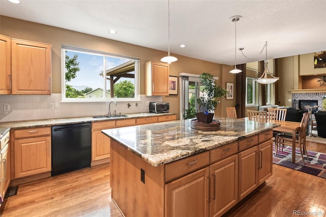 15962 W 70th Dr, Arvada, CO 80007 - kitchen with black dishwasher, light wood-style floors, backsplash, a kitchen island, and recessed lighting