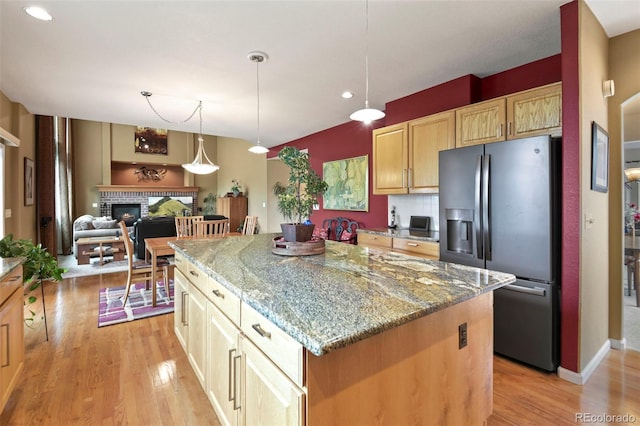 15962 W 70th Dr, Arvada, CO 80007 - kitchen with stainless steel fridge with ice dispenser, light wood finished floors, light stone countertops, a kitchen island, and recessed lighting
