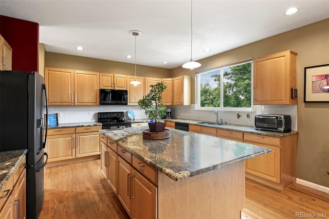 15962 W 70th Dr, Arvada, CO 80007 - kitchen with black appliances, light wood finished floors, decorative backsplash, a kitchen island, and dark stone counters