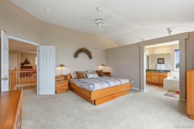 15962 W 70th Dr, Arvada, CO 80007 - bedroom with lofted ceiling, light carpet, connected bathroom, and a ceiling fan