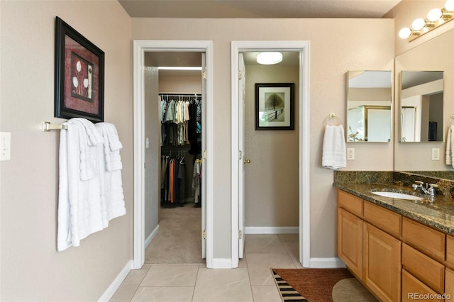 15962 W 70th Dr, Arvada, CO 80007 - full bath with tile patterned flooring, vanity, and a walk in closet