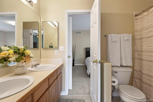 15962 W 70th Dr, Arvada, CO 80007 - full bath with double vanity, tile patterned flooring, connected bathroom, and a ceiling fan