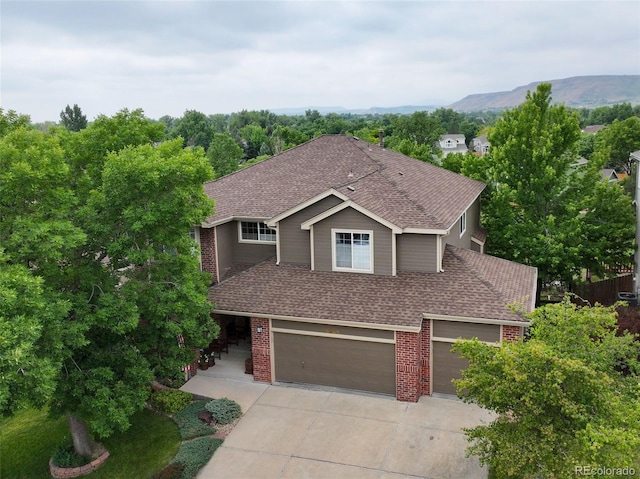 15962 W 70th Dr, Arvada, CO 80007 - view of front of home with roof with shingles, brick siding, driveway, and an attached garage