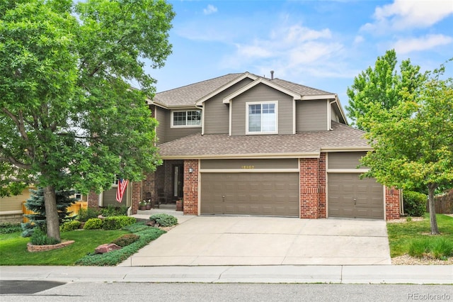 15962 W 70th Dr, Arvada, CO 80007 - view of front of home with concrete driveway, roof with shingles, a garage, and brick siding