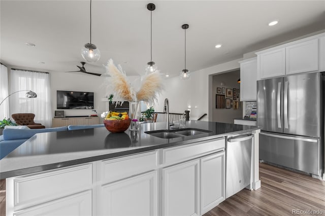 14431 Forest St, Thornton, CO 80602 - kitchen with stainless steel appliances, a sink, open floor plan, white cabinets, and dark countertops