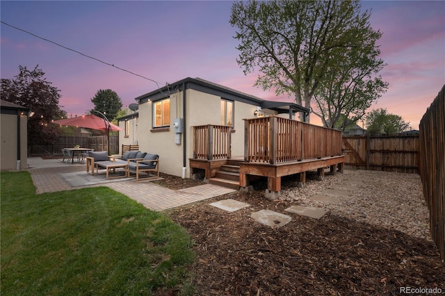 back of house with a deck, a patio, stucco siding, and an outdoor living space
