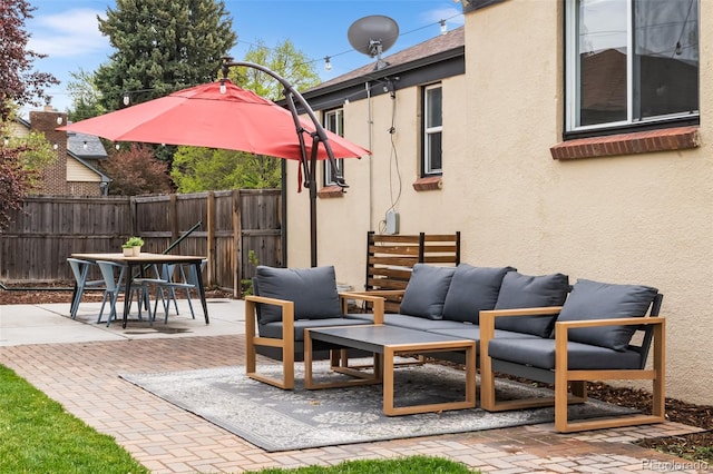 view of patio with an outdoor living space, fence, and outdoor dining space