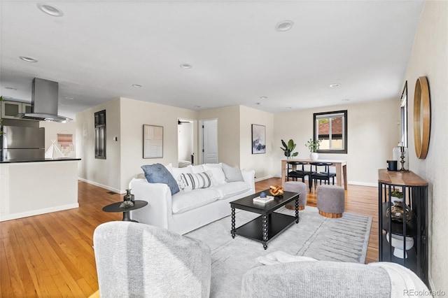 living room featuring baseboards, wood finished floors, and recessed lighting