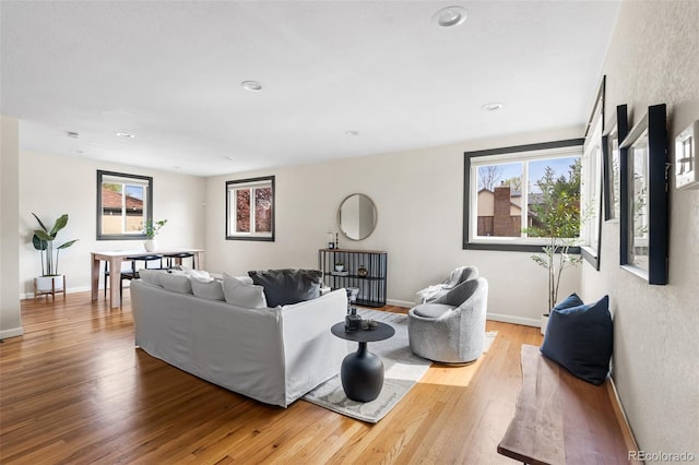 living area with wood finished floors, baseboards, and recessed lighting