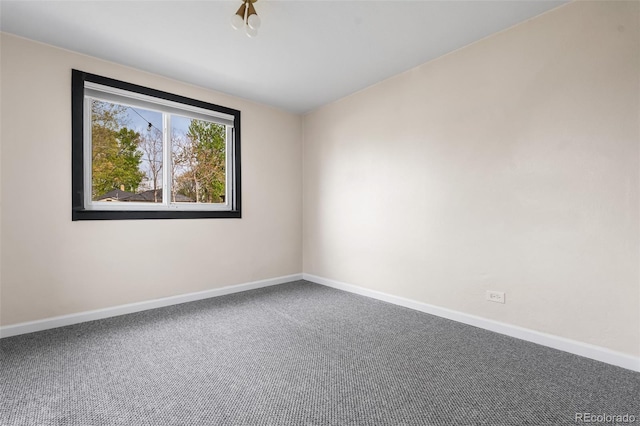spare room with baseboards and carpet flooring