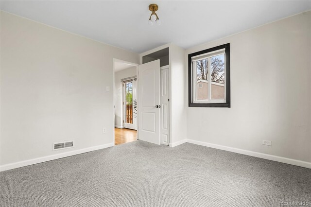 unfurnished room with carpet floors, healthy amount of natural light, and baseboards