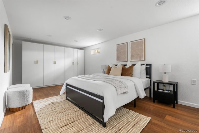 bedroom with wood finished floors, recessed lighting, and baseboards