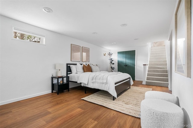 bedroom featuring wood finished floors, baseboards, and recessed lighting