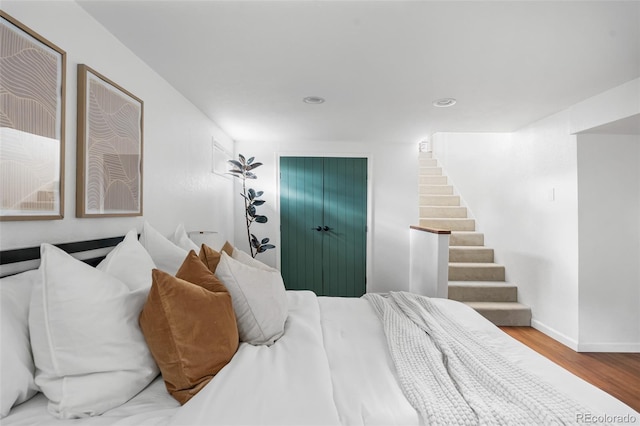 bedroom featuring wood finished floors, baseboards, and recessed lighting