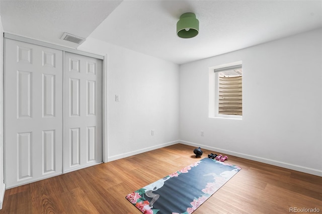 unfurnished bedroom with baseboards, wood finished floors, and a closet