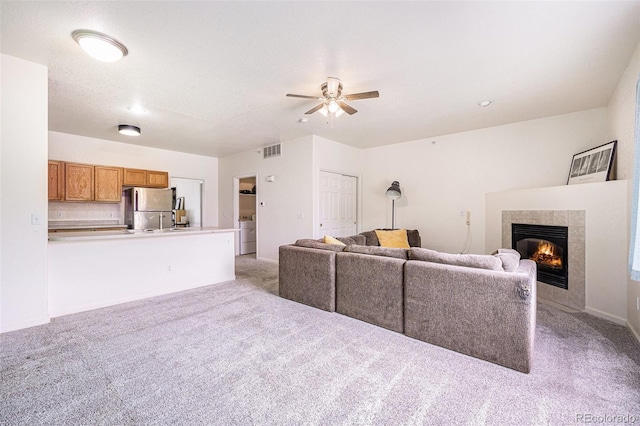 18038 Becket Dr, Parker, CO 80134 - living area with a ceiling fan, light carpet, a tile fireplace, and washer / clothes dryer