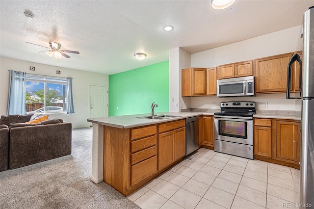 18038 Becket Dr, Parker, CO 80134 - kitchen with stainless steel appliances, open floor plan, a sink, a peninsula, and brown cabinetry