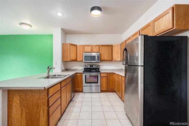 18038 Becket Dr, Parker, CO 80134 - kitchen featuring appliances with stainless steel finishes, a sink, light countertops, and brown cabinets