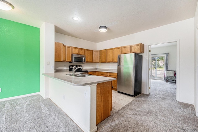 18038 Becket Dr, Parker, CO 80134 - kitchen featuring appliances with stainless steel finishes, a sink, light carpet, a peninsula, and light countertops