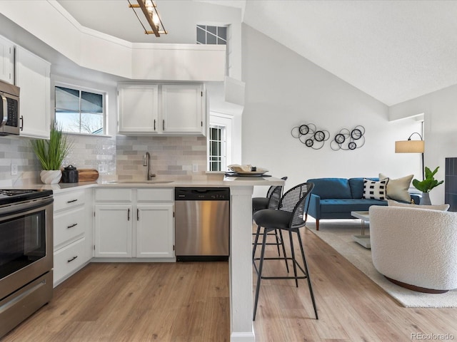 kitchen featuring a sink, white cabinetry, stainless steel appliances, and light countertops