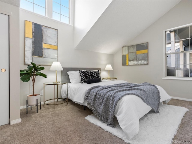 carpeted bedroom with vaulted ceiling and baseboards