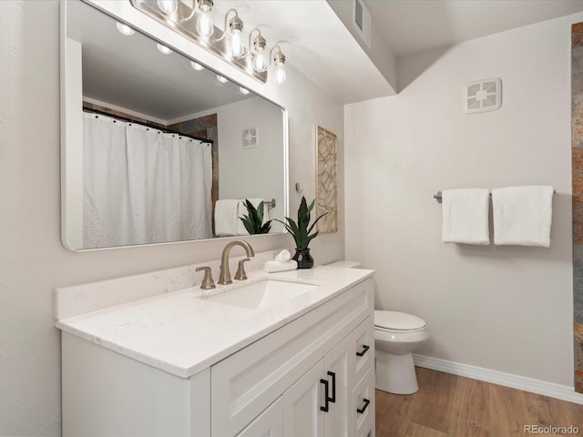 full bath with visible vents, toilet, vanity, wood finished floors, and baseboards