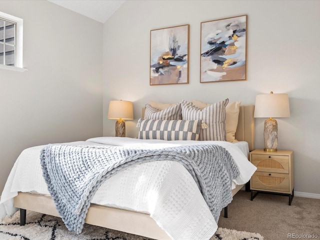 bedroom with light carpet, baseboards, and vaulted ceiling