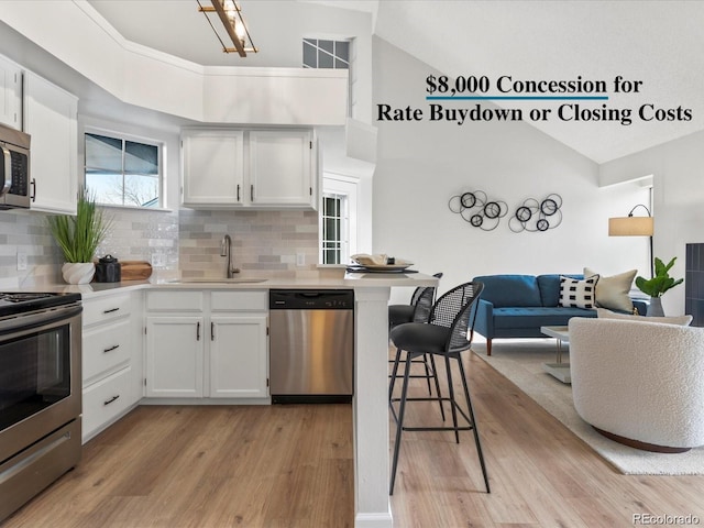 11195 Alcott St Unit D, Westminster, CO 80234 - kitchen featuring stainless steel appliances, light countertops, decorative backsplash, light wood finished floors, and high vaulted ceiling