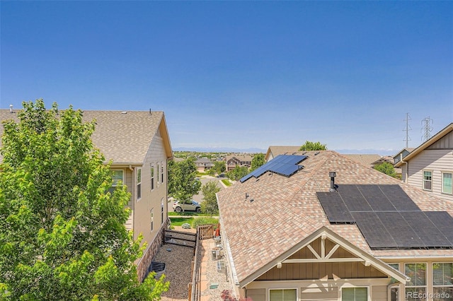 7845 S Flat Rock Way, Aurora, CO 80016 - view of property exterior with roof mounted solar panels, a shingled roof, board and batten siding, and a residential view