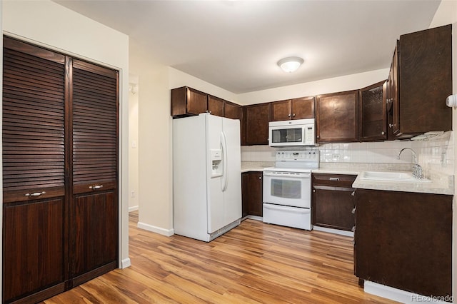 350 S Clinton St Unit 2A, Denver, CO 80247 - kitchen featuring white appliances, dark brown cabinetry, light wood finished floors, tasteful backsplash, and light countertops