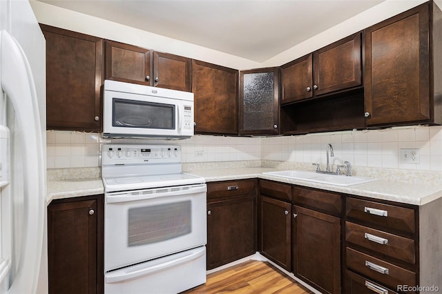 350 S Clinton St Unit 2A, Denver, CO 80247 - kitchen with white appliances, dark brown cabinets, backsplash, and light countertops