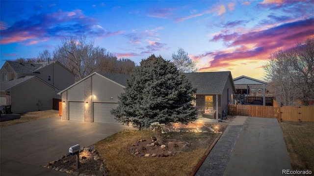 view of front facade with driveway, an attached garage, fence, and a gate