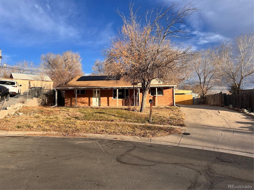 single story home featuring solar panels