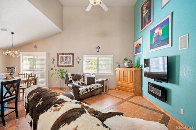 tiled living room with ceiling fan with notable chandelier, high vaulted ceiling, and a healthy amount of sunlight