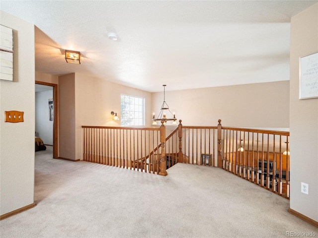 carpeted empty room featuring a chandelier