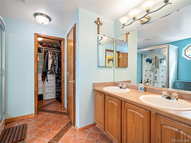 bathroom with vanity, tile patterned floors, and a shower with door