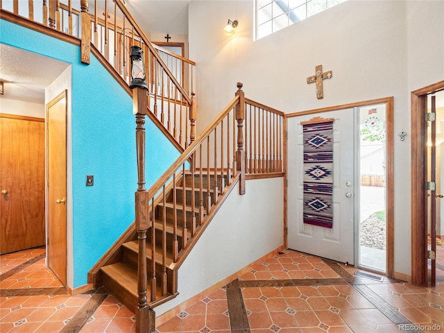 entryway with tile patterned flooring and a towering ceiling