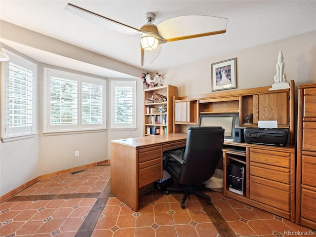 home office with ceiling fan and dark tile patterned flooring