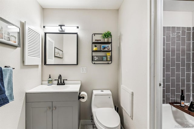 bathroom with a shower, vanity, and toilet